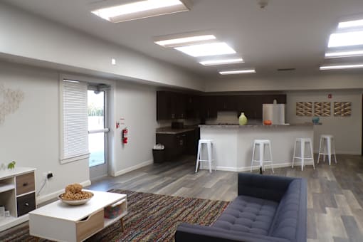 A living room with a couch, a coffee table, and a bar area.