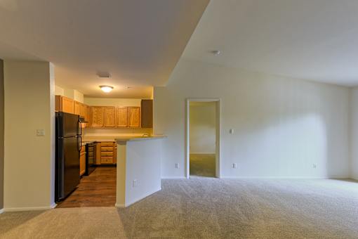 an empty living room with a kitchen in it