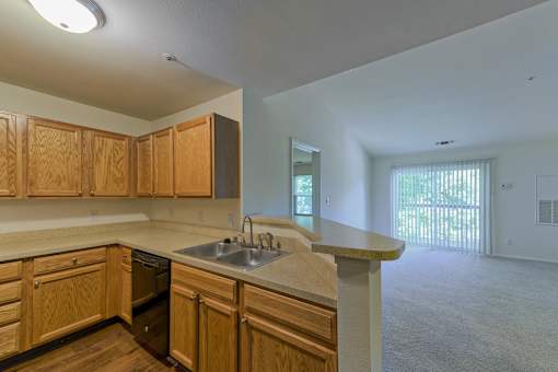 an empty kitchen with wooden cabinets and a sink