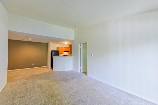 the living room and kitchen of an empty apartment