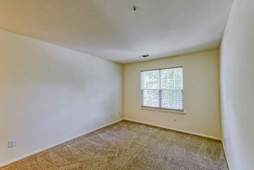 the living room of a home with carpet and a window