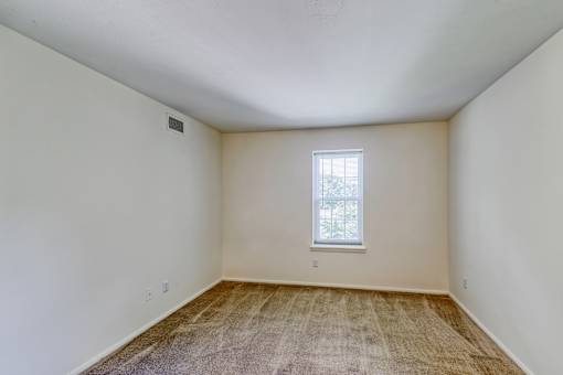 an empty room with carpet and a window