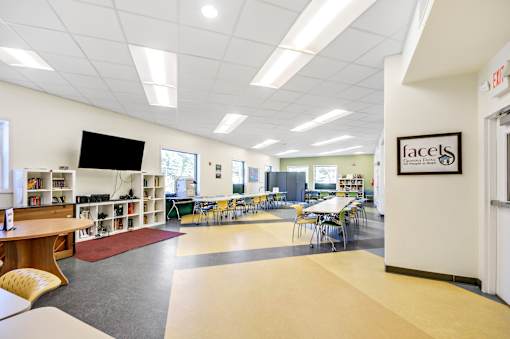 A library with tables, chairs and bookshelves.
