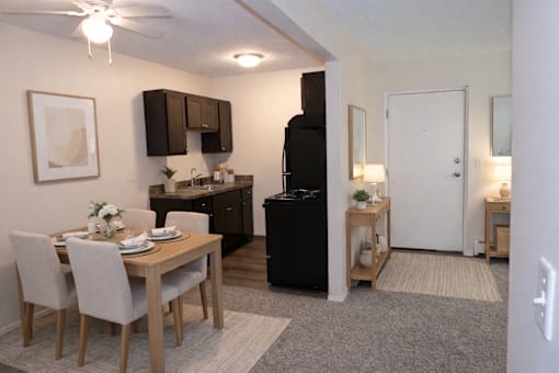 A kitchen with a dining table and chairs.