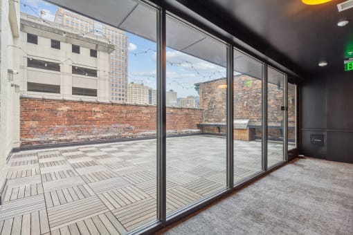 a balcony with a brick wall and glass doors