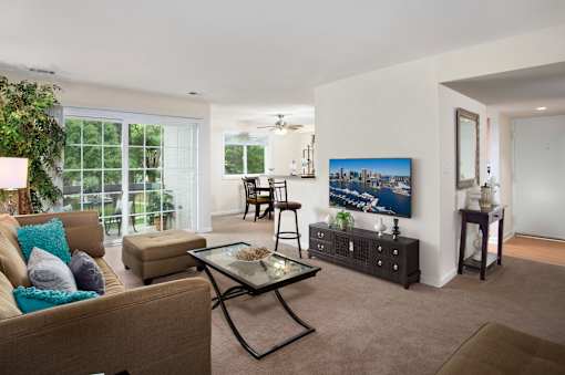 A living room with a couch, a coffee table, and a painting on the wall.