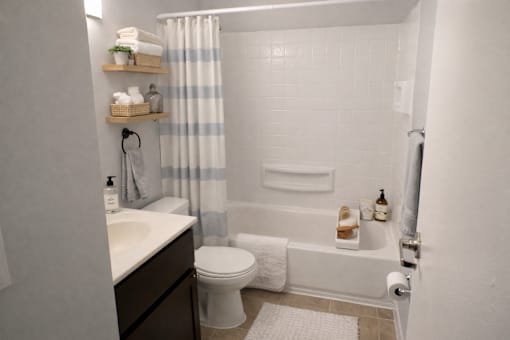 A white bathroom with a toilet, sink, and bathtub.