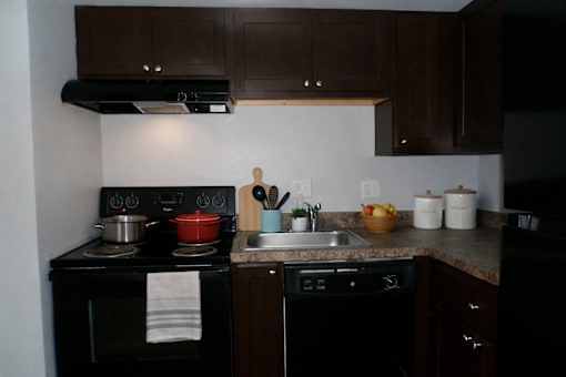 A kitchen with a black oven and a black stove top.