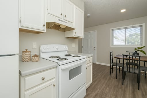 A kitchen with white appliances and cabinets.