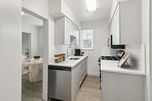 a renovated kitchen with white cabinets and a white counter top