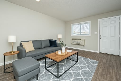A grey couch with a wooden table in front of it.