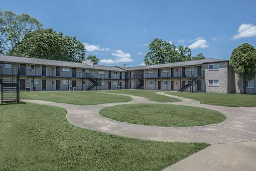 A large grassy area in front of apartment buildings.