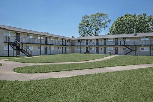 A long building with a green lawn in front.