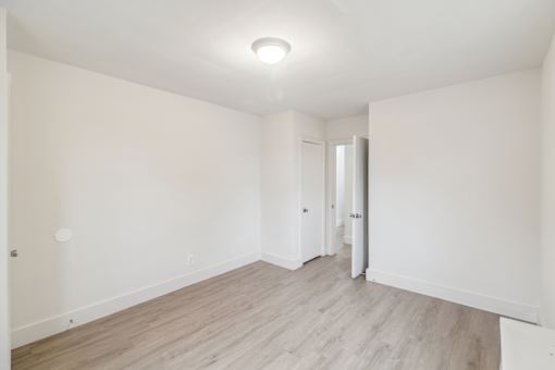 a living room with white walls and a wood floor