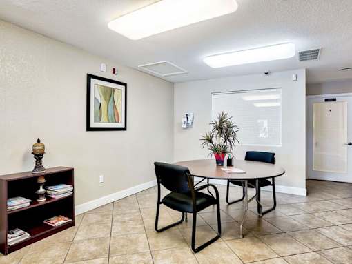 A room with a table, chairs, and a bookshelf.