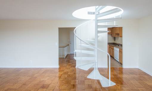 A spiral staircase in a room with wooden floors.
