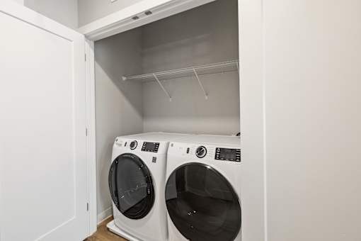 Two white front loading washing machines in a laundry room.