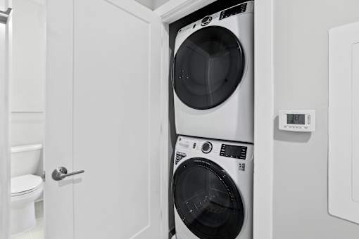 A white washing machine is in a small laundry room.