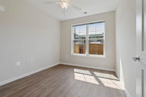 an empty room with wood floors and a window