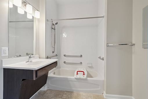 a bathroom with a tub and a sink and a mirror