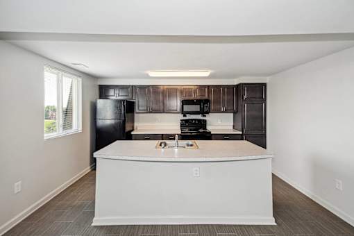 a kitchen with a white counter top and a black refrigerator