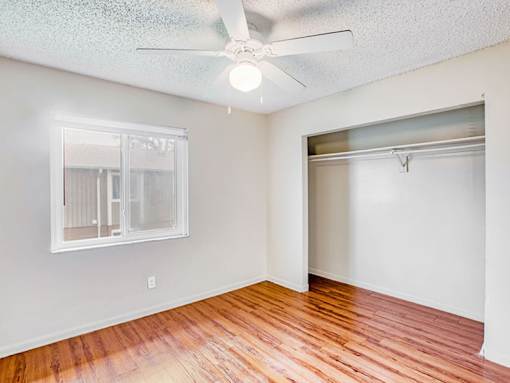 A room with a ceiling fan and a window.