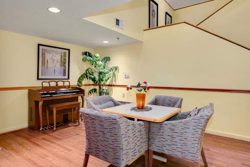 a dining room with a table and chairs and a piano