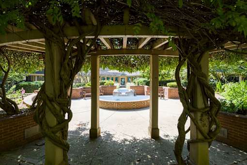 a gazebo with a fountain in the middle of a courtyard