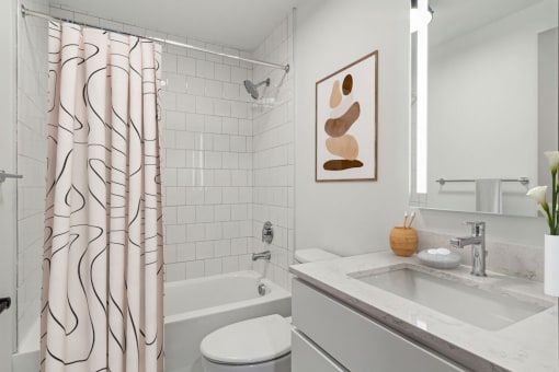 a white bathroom with a shower curtain and a sink