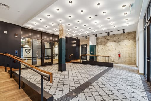 the lobby of a building with a staircase and glass doors