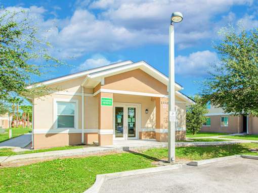 A building with a brown facade and a green lawn in front.