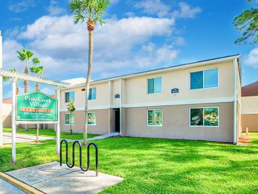 A building with a sign that says "Fine Creek Village" in front of it.