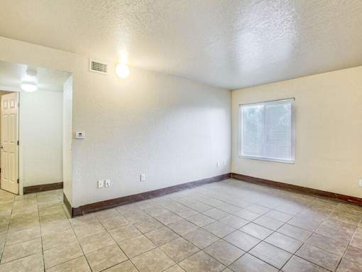 A room with a tiled floor and a window with a white frame.