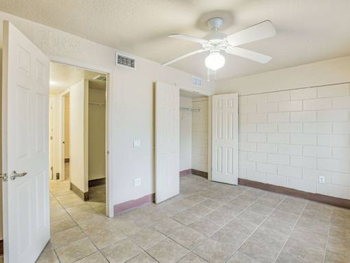 A room with a ceiling fan and tile flooring.