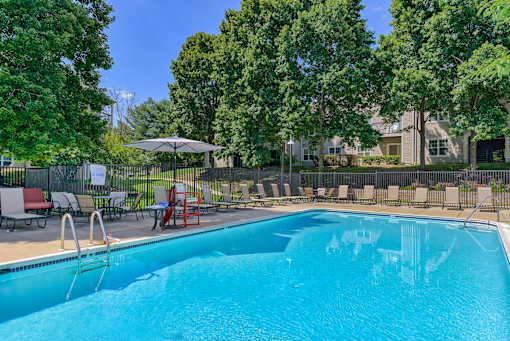 a swimming pool with chairs and umbrellas next to a pool
