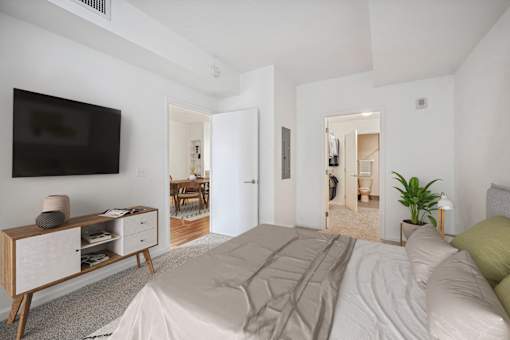 a bedroom with a large bed and a tv on the wall
