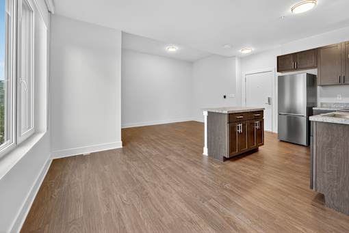 A kitchen with a refrigerator, sink, and cabinets.