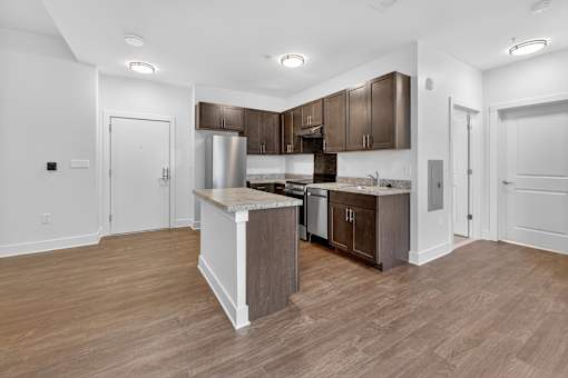 A kitchen with a white island and wooden floors.