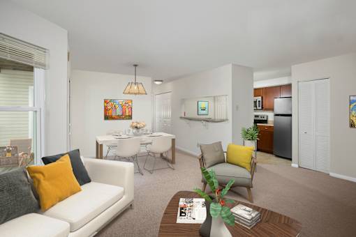 A living room with a white couch, a coffee table, and a dining table.