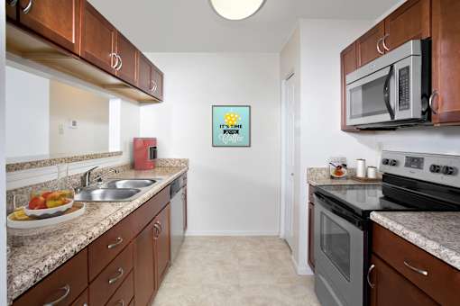 A kitchen with brown cabinets and a white fridge.