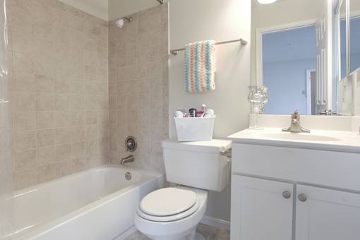 A white toilet sits next to a white sink in a bathroom.