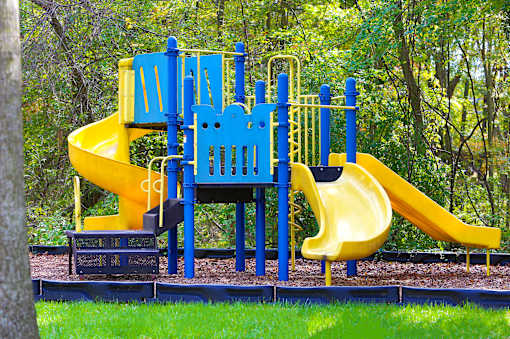 A playground with a blue and yellow slide.