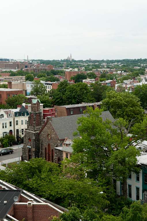 A cityscape with a church in the foreground and a domed building in the distance.