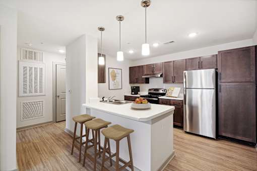A kitchen with a white island and brown bar stools.