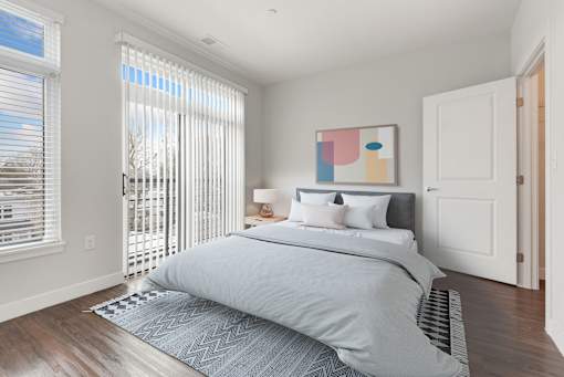 A bedroom with a large bed and a painting on the wall.