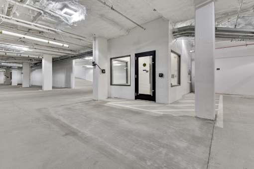 A large, empty room with white walls and a concrete floor.
