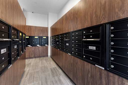 A long hallway with mailboxes on the wall.