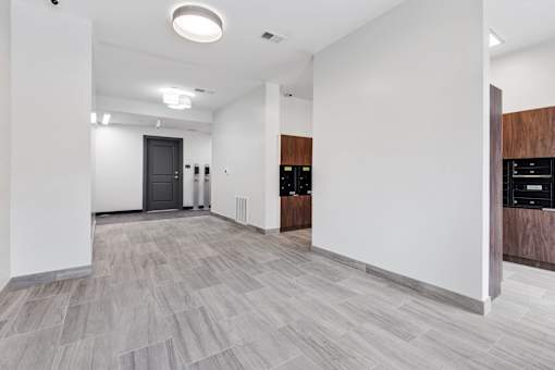 A spacious room with a grey floor and white walls.