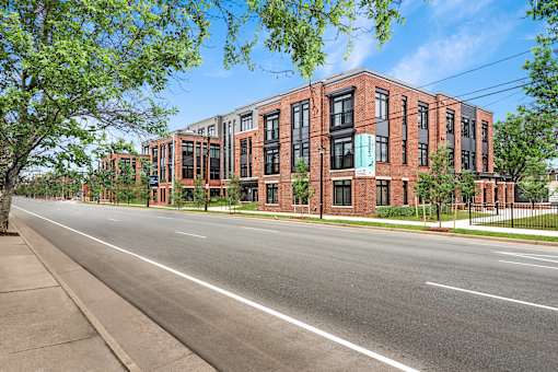 A street view of a red brick building with a clear blue sky above.