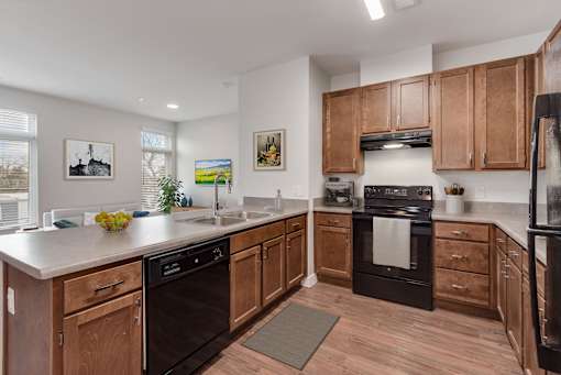 A kitchen with wooden cabinets and black appliances.